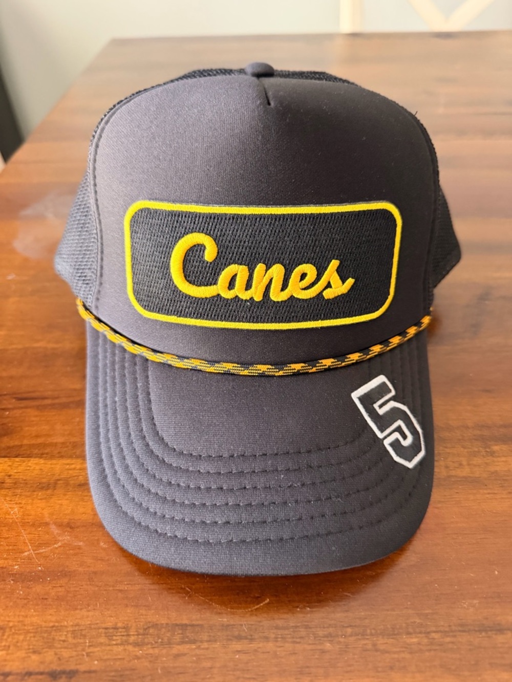 Black Mesh Trucker Cap with Embroidered Canes Logo in Yellow